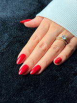 Scarlett cherry red long almond press-on nails — closed fist view