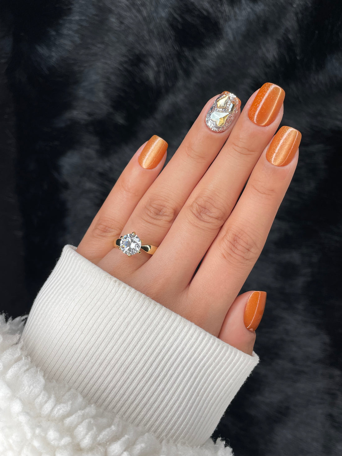 Ambre press on nails — amber shimmer with crystal accent, hand shot close-up
