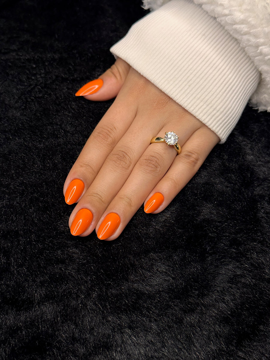 Close-up of Joséphine neon orange almond press on nails