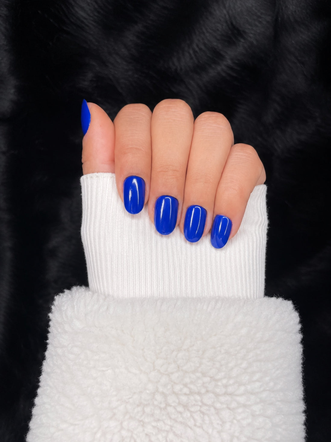 Saphir royal blue almond nails closed fist view — Nailora Paris
