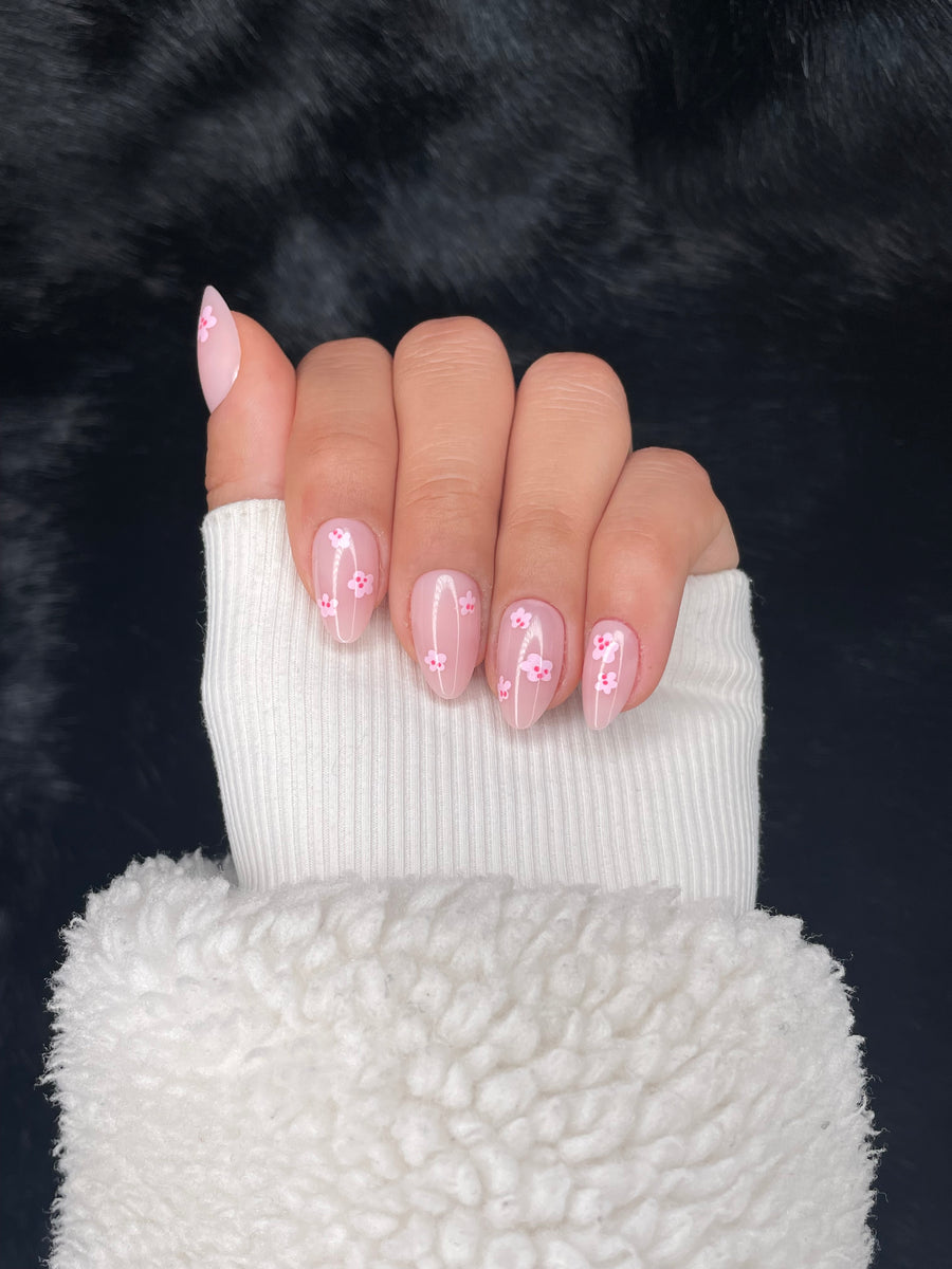 Solange nude floral almond press on nails hand pose – Nailora Paris