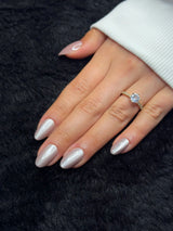 Close-up of Théa nude pearl chrome almond press on nails