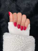 Valentine cherry red medium round fake nails — fist pose showing glossy finish